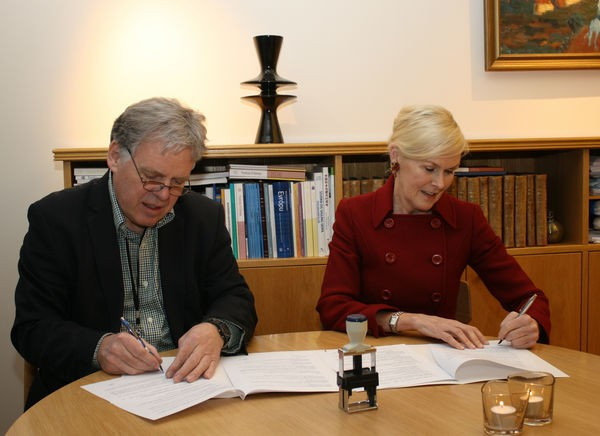 Ragnhildur Hjaltadóttir ráðuneytisstjóri og Bjarni Stefánsson sýslumaður skrifa undir samninginn.
Mynd: Innanríkisráðuneytið.