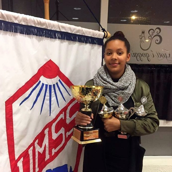 Andrea Maya með fangið fullt af bikurum á uppskeruhátíð UMSS. Mynd: UMSS.