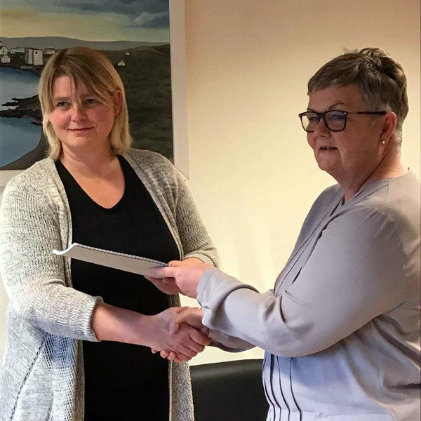Guðný Hrund Karlsdóttir, sveitarstjóri Húnaþings vestra, tekur við skýrslunni úr hendi Bryndísar Þráinsdóttur, framkvæmdastjóra Farskólans. Mynd: Hunathing.is.