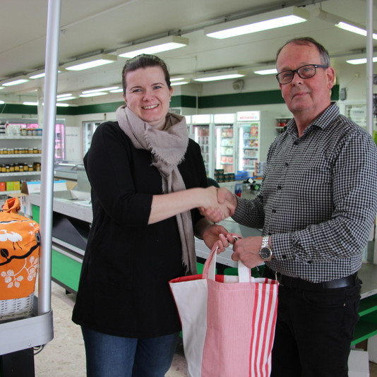 Svanhildur Pálsdóttir afhendir Pétri Stefánssyni, verslunarstjóra í KS Varmahlíð, poka sem saumaður var upp úr gömlu dúkunum á Löngumýri. Mynd:FE