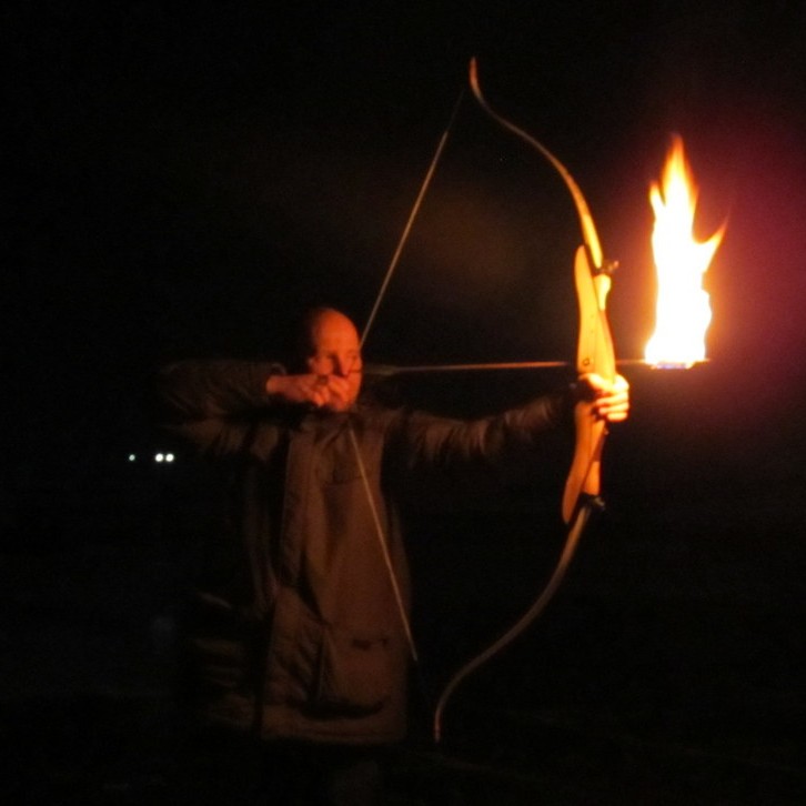 Kveikt í áramótabrennu með boga og logandi ör