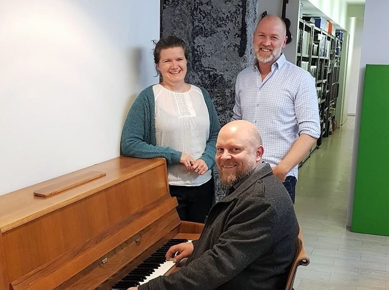 Svanhildur og Jökull standa við píanóið sem Áskell Heiðar leikur á. Mynd af FB.