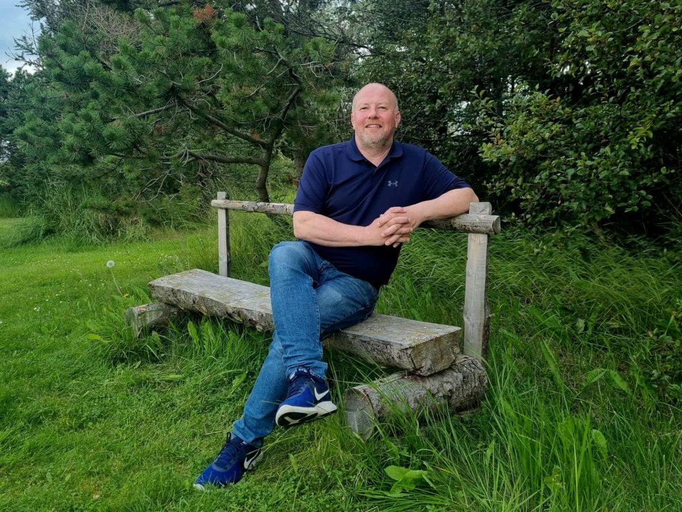 Gunnar Rögnvaldsson staðarhaldari lætur fara vel um sig í garðinum á Löngumýri. Mynd: HMJ.