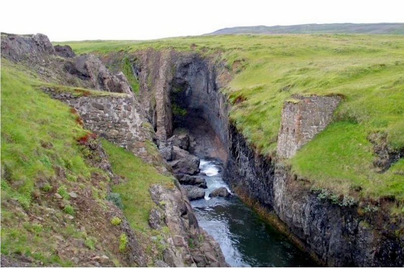 Leifar fyrstu brúarinnar yfir Laxá. Hægra megin er brúarendinn í landi Höskuldsstaða en vinstra megin í landi Sölvabakka. Horft er niður ána til norðurs. Mynd og myndatexti: Byggðasafn Skagfirðinga.