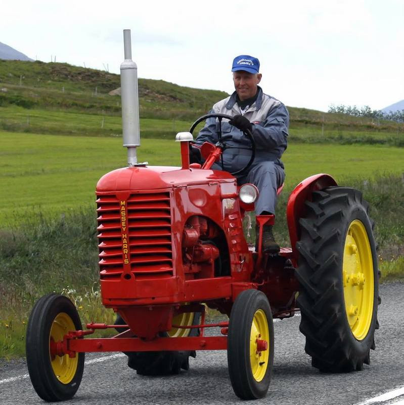 Simmi safnstjóri á Massey Harris dráttarvél sem hann hefur gert upp. Mynd af FB.