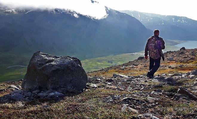 Myndin er tekin af forsíðu Bændablaðsins og sýnir Jón ganga á föll í Fljótum í leit að mink.