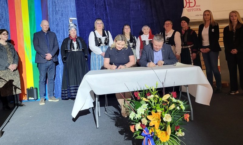 Lilja Dögg Alfreðsdóttir, menningar- og viðskiptaráðherra, og Sigfús Ingi Sigfússon, sveitarstjóri, skrifa undir undir samkomulag um byggingu Menningarhúss á Sauðárkróki að viðstöddum fulltrúum sveitarstjórnarfulltrúum og prúðbúnum konum í Pilsaþyt. Myndir: PF.