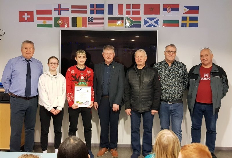 Óskar Björnsson, skólastjóri, Una Karen Guðmundsdóttir og Jón Gabríel R. Marteinsson, fulltrúar skólans, Alfreð Guðmundsson, formaður Lionsklúbbs Sauðárkróks og fulltrúar hans; Bragi Haraldsson, Gunnar Björn Ásgeirsson og Rögnvaldur Valbergsson. Fyrir ofan hópinn má sjá þjóðfána allra nemenda skólans. Mynd: PF.