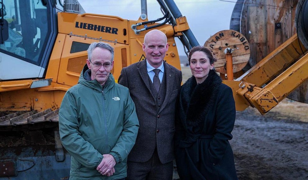 Magnús Hauksson, framkvæmdastjóri Öryggisfjarskipta, Eyjólfur Ármannsson innviðaráðherra og Alexandra Jóhannesdóttir, sveitarstjóri Skagastrandar stilltu sér upp fyrir framan vinnuvélarnar á Skagaströnd. Þær hafa verið notaðar við að leggja ljósleiðara og tryggja tvítengingu fyrir svæðið. MYND AF STJORNARRADID.IS