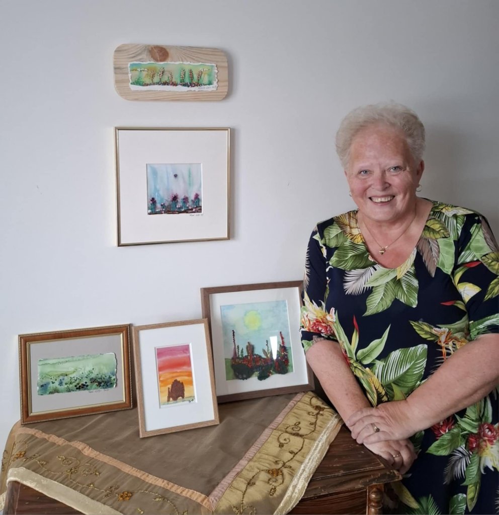 Ragnheiður með nýjustu listaverkin. Útsaumaða vatnslitamyndir sem er nýjasta dellan. MYND AÐSEND