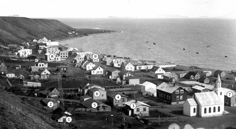 Mynd: Sauðárkrókur um 1910. Í þessu umhverfi ólst Eyþór upp og starfaði. Stefánsbær (1), nú Skógargata 18, stendur í brekkurótunum, reistur 1904. Hvammur (2), áður Halldórshús, þar fyrir norðan, nú Skógargata 12. Halldór Þorleifsson járnsmiður byggði það 1898 og bjó þar til 1918 að Þorvaldur Þorvaldsson keypti það og stækkaði til suðurs, verkamaður og ökumaður, verkalýðsleiðtogi um árabil, kvæntur Helgu Jóhannesdóttur og áttu þau sjö börn; meðal þeirra var Rannveig sem lengi söng í kirkjukórnum hjá Eyþóri. Kirkjuhvol (3) byggði Steindór Jóhannesson 1906 en þar bjó lengi Friðrik Hansen kennari með fjölskyldu sinni og byggði hann aðra hæð ofan á húsið; nú Skógargata 15. Sólvang (4) reisti Jónas Sveinsson árið 1904 en Jón Þ. Björnsson keypti húsið 1911 og byggði síðar efri hæðina, nú Skógargata 13. Fjós (5) Jóns Þ. og Friðriks stóð þétt við hús þeirra; síðar reisti Friðrik sitt eigið fjós. Góðtemplarahúsið (6), Gúttó, Skógargata 11, var reist 1897 og stækkað 1903–04 og er það hærri hluti hússins. Barnaskólinn (7) var tekinn í notkun 1908. Fjær blasir við hús Kristjáns borgara (8) eins og Kristján Gíslason var oft kallaður. Hallandi þakið er á Gilsstofu sem ótvírætt var komin á sinn stað 1892 en síðan hvarf hún að hluta til inn í viðbygginguna. Í þessu húsi var verslun K.G. og íbúð. Þar átti Eyþór mörg spor. Ólafur Briem snikkari reisti það hús sem stóð við Aðalgötu 22 (9) árið 1886 og bjó þar þangað til K.G. keypti það litlu fyrr en heimsstyrjöldin hófst 1914 og opnaði þar vefnaðarvöruverslun sem jafnan var kölluð Bræðrabúð, kennd við syni kaupmannsins. Sissa var þar oft við afgreiðslu. Breski herinn tók þetta hús til sinna þarfa árið 1940 og brann það til kaldra kola 4. september um haustið. (Heimildir: Saga Sauðárkróks, Skagfirskar æviskrár, Hannes Pétursson.) HSK.
