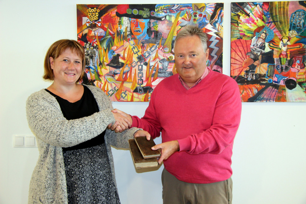 Sigrún Fossberg skjalavörður tekur við bókargjöfum Friðriks Aarsæther. Mynd: PF