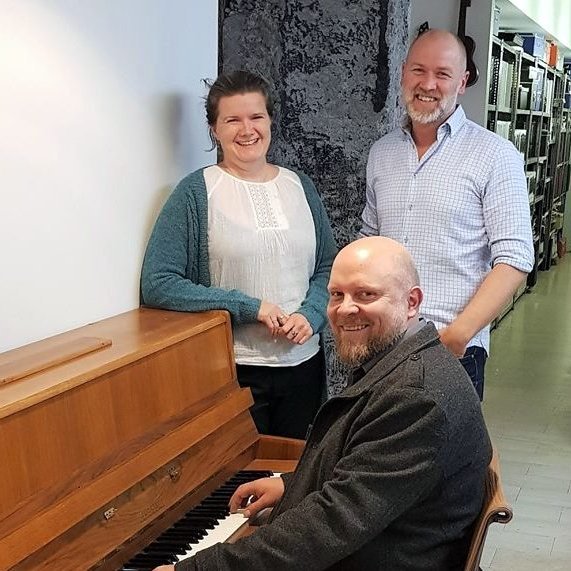 Svanhildur og Jökull standa við píanóið sem Áskell Heiðar leikur á. Mynd af FB.