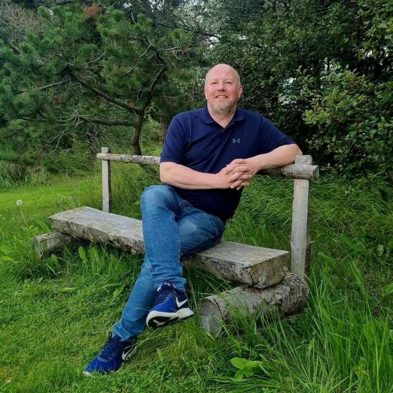 Gunnar Rögnvaldsson staðarhaldari lætur fara vel um sig í garðinum á Löngumýri. Mynd: HMJ.