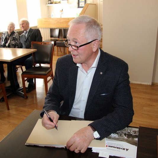 Ágúst Guðmundsson hafði nóg að gera í áritun bóka en hann var afar ánægður með góða mætingu og undirtektir hinna fjölmörgu gesta sem kom á útgáfuhóf Á Króknum 1971. Mynd: PF.