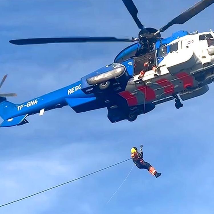 Starfsmaður Gæslunnar á leið milli Arnars og þyrlunnar. SKJÁSKOT