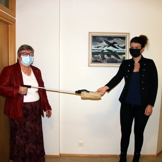 Það var vel gætt að sóttvörnum og tveggja metra reglunni þegar afmælisbarnið, Ásta Ólöf Jónsdóttir, afhenti Guðrúnu Hönnu Kristjánsdóttur gjafabréf að garðskúr sem var afrakstur gjafa frá afmælisgestum hennar. Mynd: PF.