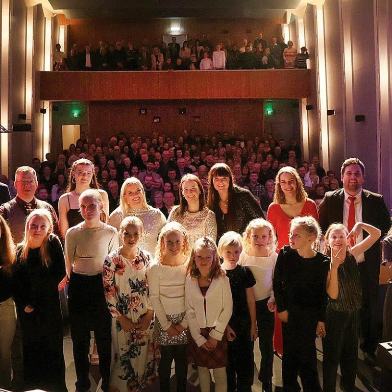 Listafólkið pósar að loknum tónleikum með tónleikagesti í bakgrunni. AÐSEND MYND