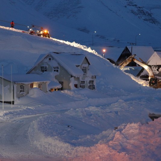 Snjótroðari og grafa brytja niður snjóhengjuna. Mynd:FE