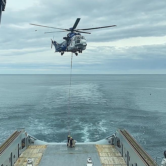 Skjáskot úr myndbandi Landhelgisgæslunnar sem sýnir TF-EIR lyfta rafgeymunum frá varðskipinu Freyju. Það sést glitta í Málmey lengst til hægri á myndinni. MYND: LHG