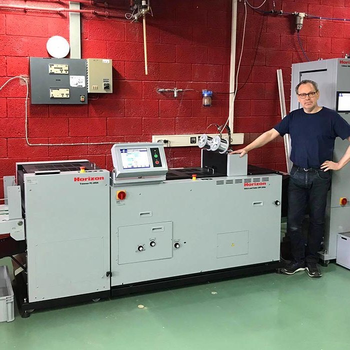 Guðni við nýju röðunarvélina sem breiðir heldur meir úr sér en sú gamla. MYND: ÓAB