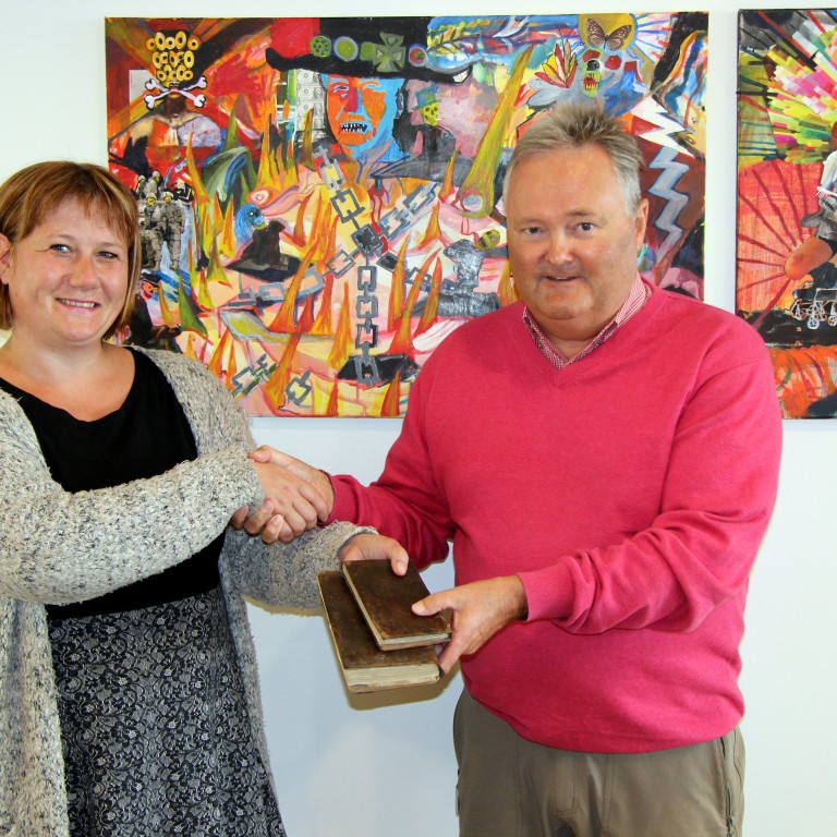 Sigrún Fossberg skjalavörður tekur við bókargjöfum Friðriks Aarsæther. Mynd: PF